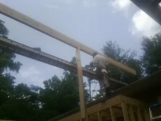 Carpenter setting a ridge beam over a new addition frame — Ice Dam Removal by Roofing Brothers in New Matamoras
